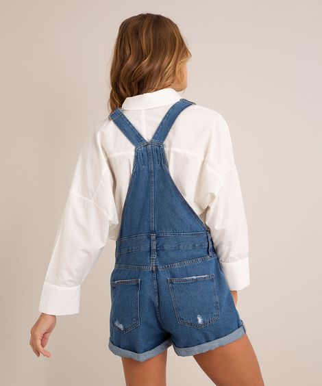 jardineira jeans com puídos  azul médio