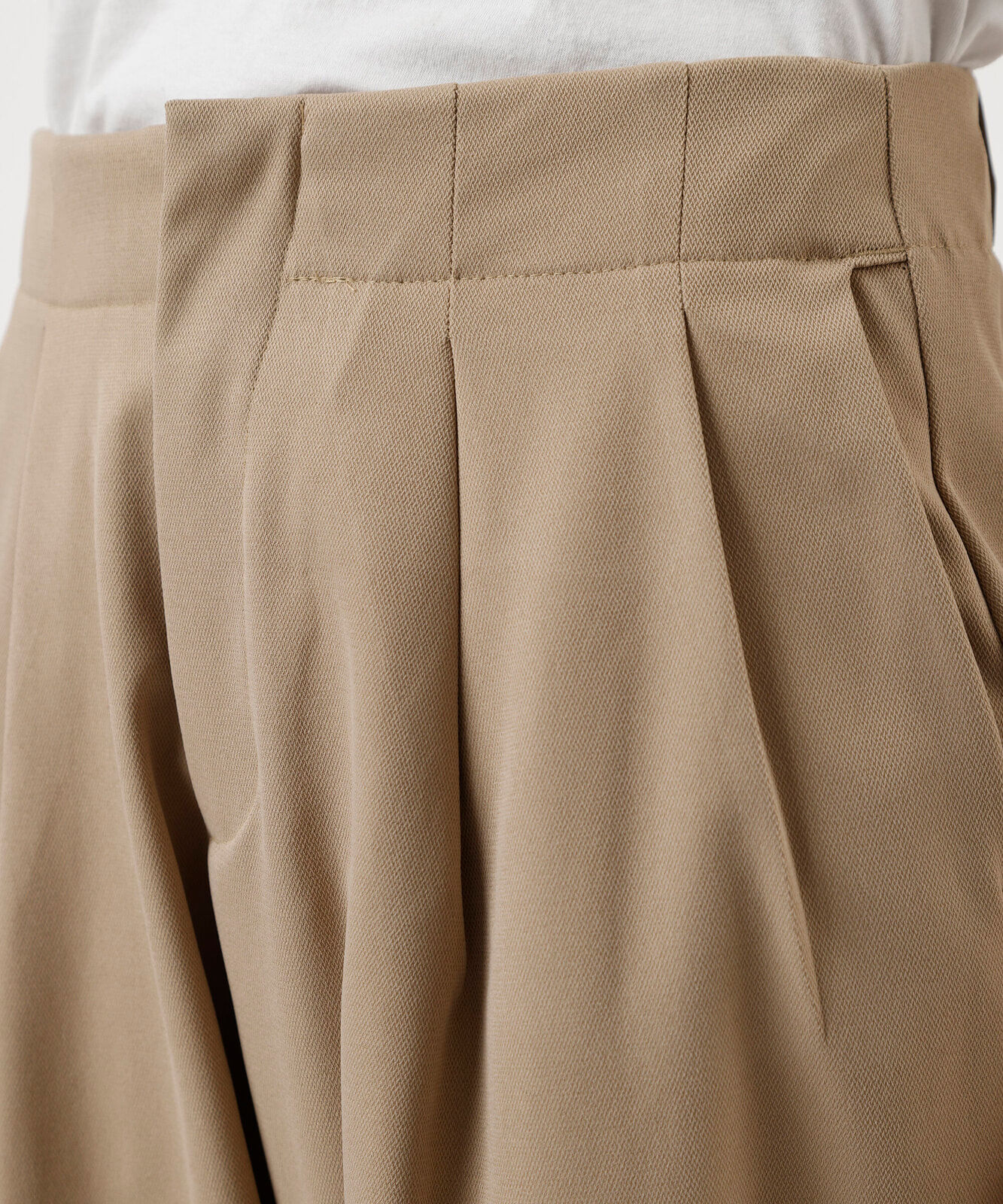 calça de alfaiataria feminina com pregas e barra dobrada bege